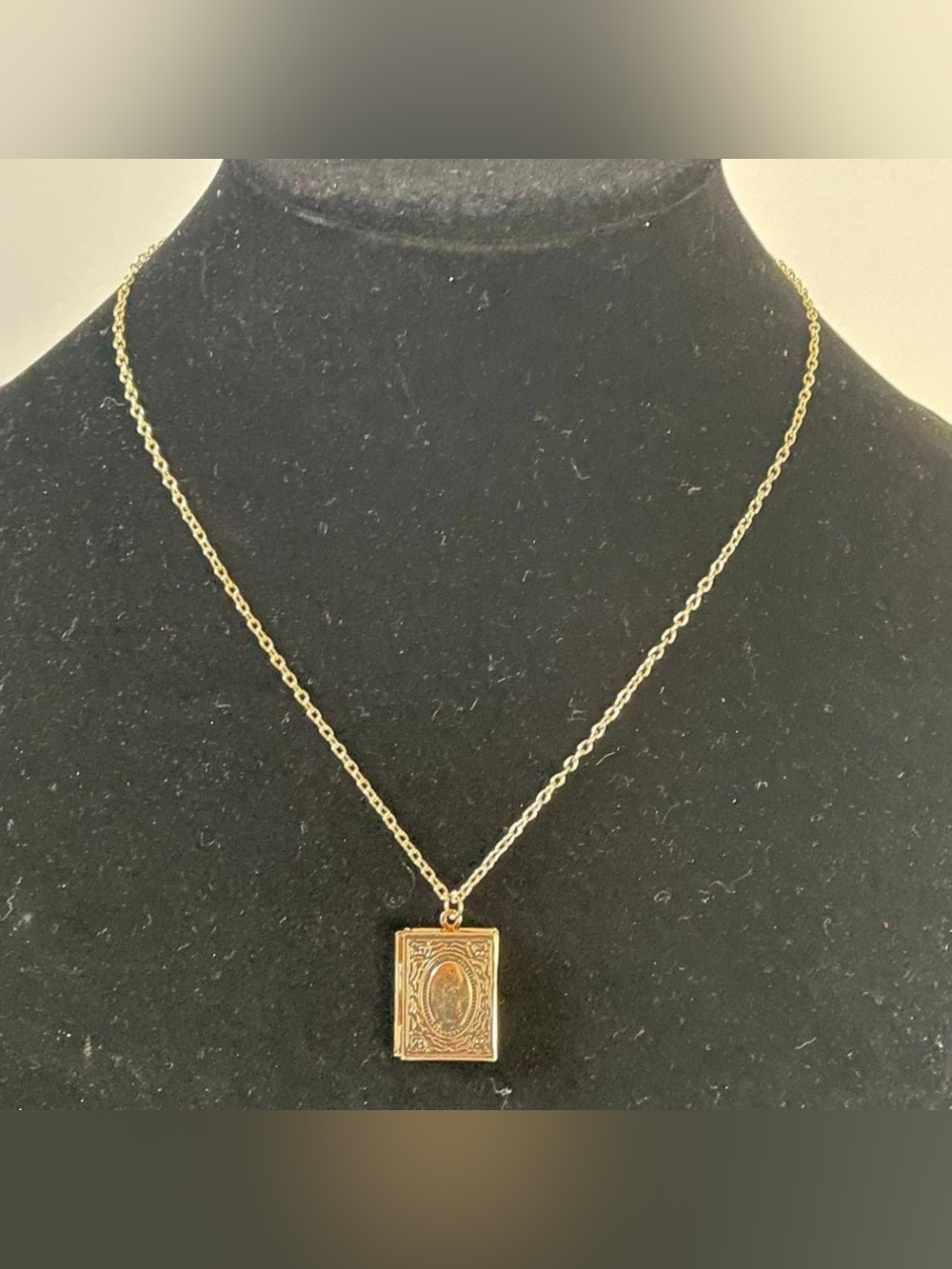 Golden stainless steel book locket necklace.